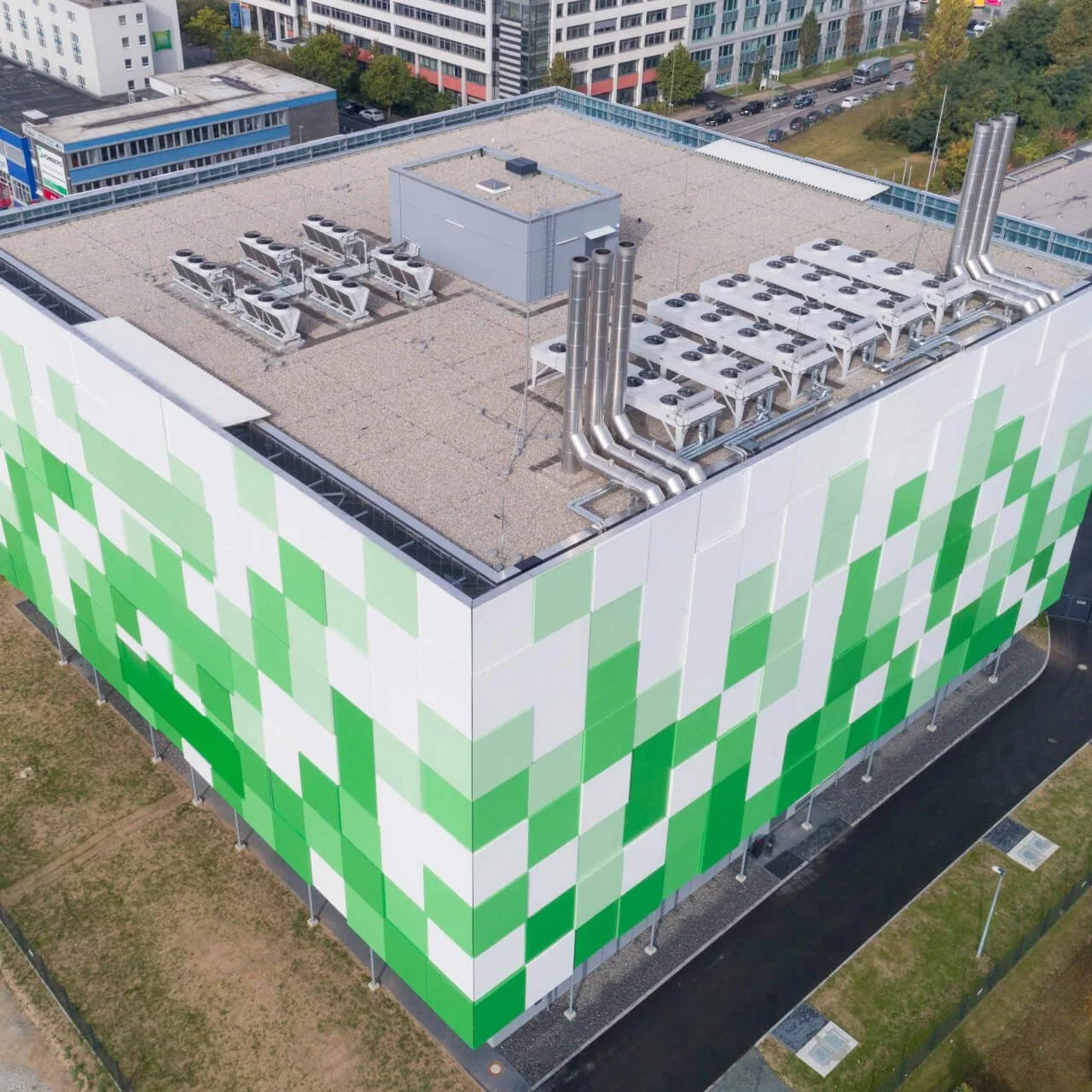 Luftaufnahme des maincubes FRA01 mit grün-weißer Fassade und Kühlanlagen auf dem Dach